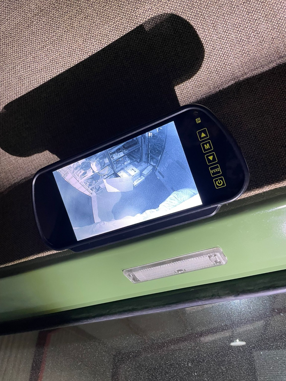 A compact monitor mount integrated into the headlining.